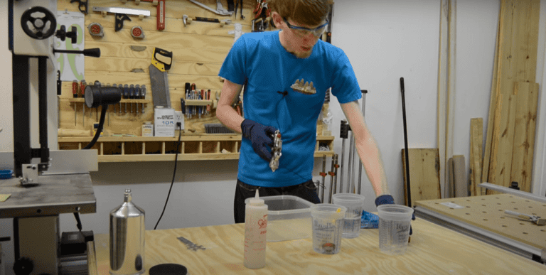 A person hold a HVLP spray gun and trying to clean it